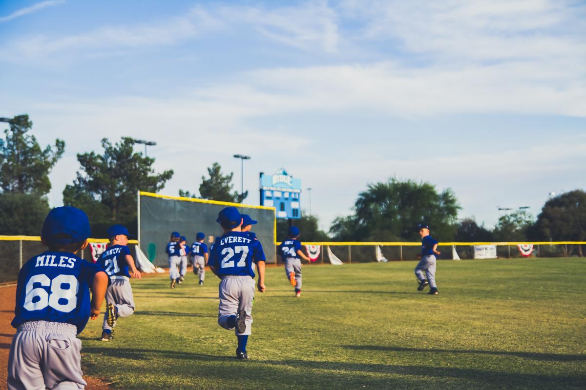 Children run onto a baseball field